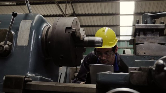 Engineer workers wear a yellow safety helmet, use tools to check and repair the machine condition in the factory to be ready for production. Career and accident insurance concepts