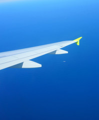 Air travel. Blue sea under the airplane wing