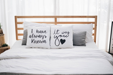 comfy wooden bed for couple decorated with "I have always known, It was you" heart pillow cosy bedroom at home valentines day, romantic date and holidays concept