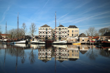 Old ancient warehouses and ships are reflecting on the Turfsingel of the town Gouda