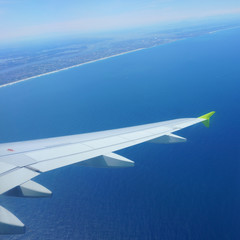 Airplane landing. Blue sea under the airplane wing