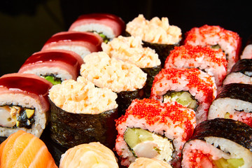 Various kinds of sushi roll set served on black stone. Japanese food
