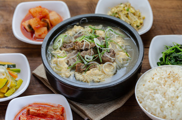 One big set of galbitang, korean style beef soup, serve with many slide dish and rice on wood table with nature light. For food issue.