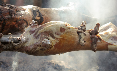 Barbecue picnic at country fair. Whole lamb roasted at spit. Street vendor, professional cooking bbq food.