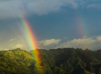 Wonderful landscape of a mountain with two rainbows in Bello, Colombia with a beautiful blue sky.