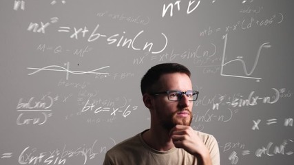 Man with glasses thinks about a mathematical problem and comes up with the solution. Animated formulas, graphs and an enlightening light bulb. - Powered by Adobe
