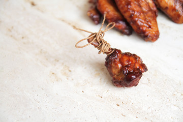  fried chicken wings on a marble surface, with spices and herbs.