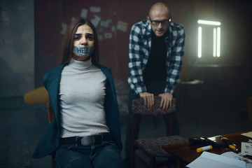 Maniac kidnapper and his victim with taped mouth