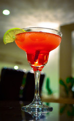 illuminated red alcoholic cocktail drink standing on the table