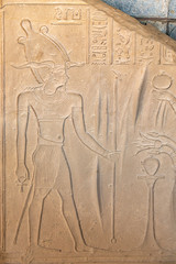 Ancient Egyptian drawings, bas-reliefs with images of people, kings, pharaohs, gods and signs on a stone wall in Aswan