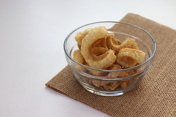 pork snack, pork rind, pork scratching, pork crackling , asia food  in bowl on white table background