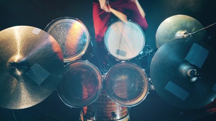 View from above on the drums and cymbals during playing. Drum set, drum kit in dark, drummer plays a concert.