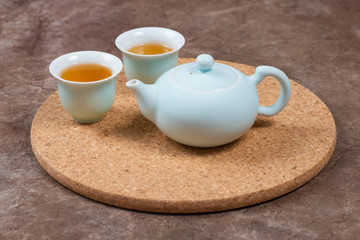 Close up view porcelain ware with tea on cork stand