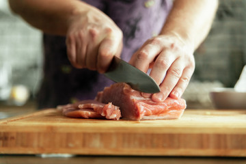 chef cutting meat on board