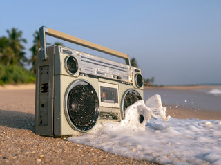 Tape recorder in sea foam and waves.