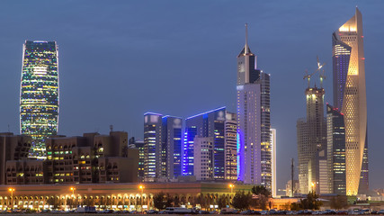 Fototapeta na wymiar Skyline with Skyscrapers day to night timelapse in Kuwait City downtown illuminated at dusk. Kuwait City, Middle East