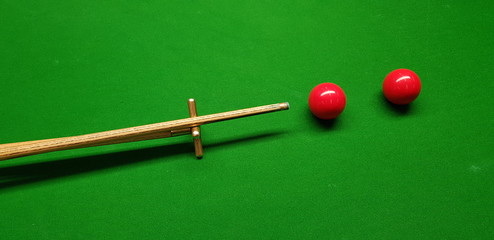 snooker balls and cue on a green table
