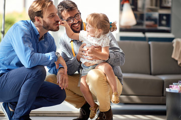 gay parents with child in store for household