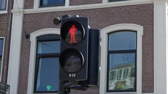 European pedestrian crosswalk sign. Traffic lights change from red to green color. Cross road intersection in Dutch street. Rules of road Europe downtown-Dan
