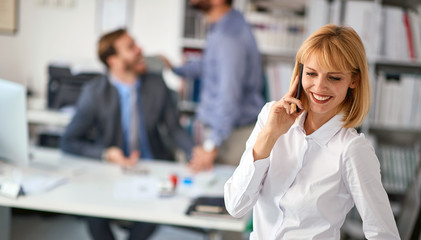 Woman worker at office.business woman enjoying at workand talking on a mobile phone.