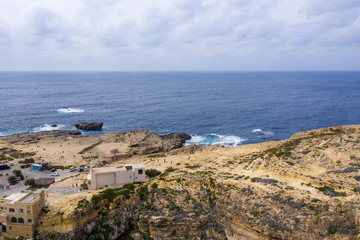 Fototapeta na wymiar Aerial drone view of rocky coastline and sea. Blue hole and the collapsed Azure window in Dwejra Bay, Gozo, Malta