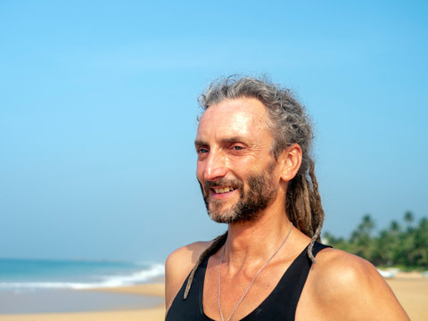Portrait of a man with dreadlocks on his head at the beach