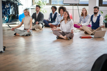 business coworkers meditating at work, sitting on the floor; copy space. modern, business, meditation concept - obrazy, fototapety, plakaty