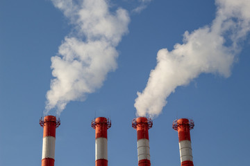 Heat and power station, smoke pipe pollution against clear blue sky