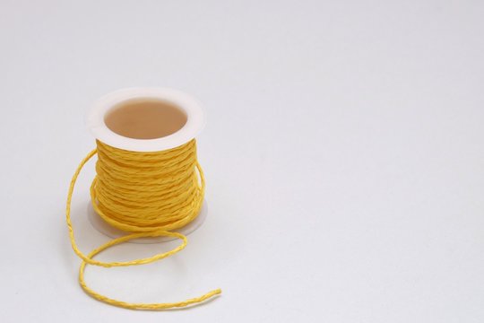 A roll ooof yellow rope thread on white isolated bacground with copy space