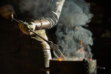 Blacksmith putting a burning item in the bucket of water - steam coming out