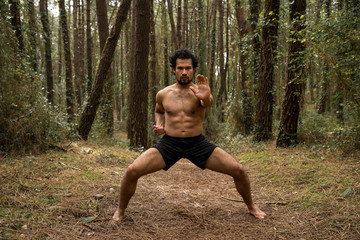 a black man training karate in the forest