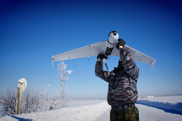  People in military uniforms launch an unmanned aerial vehicle