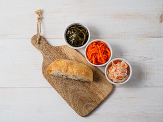 Different salads on white wooden background.
