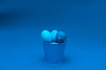 classic blue easter eggs in bucket in the center of the frame