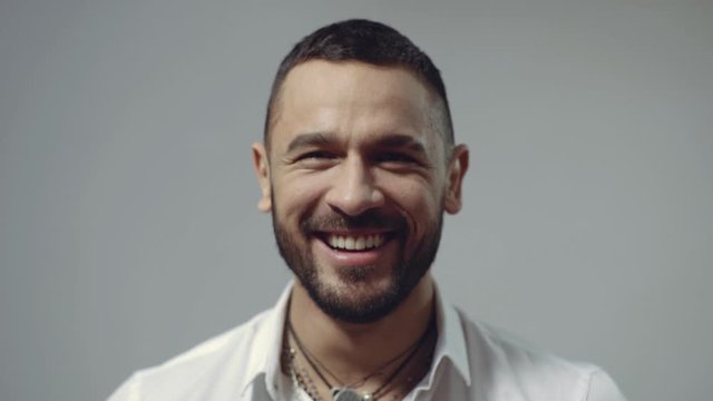 Man emotions. Portrait of smiling man close up. Successful hispanic man. Handsome smiling man on grey background looking at camera. Happy smile portrait.