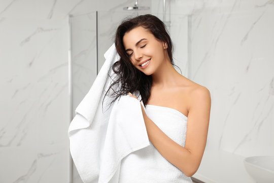 Young Woman Drying Hair With Towel In Bathroom