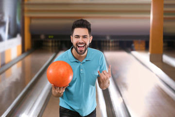 Young man with ball in bowling club