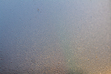 Colorful Rainy background with flowing down water drops on window glass