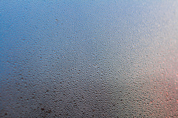 Colorful Rainy background with flowing down water drops on window glass