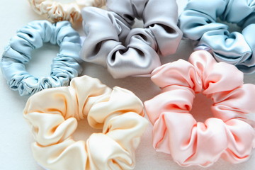 Lot of Colorful silk Scrunchies on white. Flat lay Hairdressing tools and accessories. Hair...