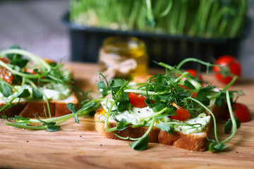 Selective focus. Healthy toasts with avocado pasta, cherry tomatoes and microgreens. Fresh juicy sprouts of peas. Trace elements. Superfoods.
