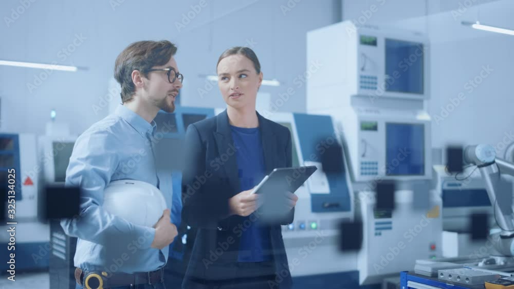 Fototapete modern factory: female project manager and male engineer standing, talking, using digital tablet for