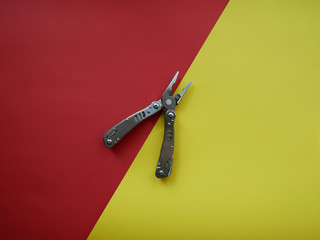 Multi tool with steel handles on a white colored background. Top view