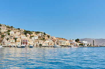 Fototapeta na wymiar Symi port, Dodecanese islands, Greece, Europe; the picturesque coastline of Symi island with beautiful traditional Greek houses and colorful buildings