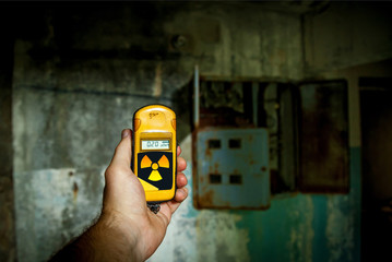 A small yellow dosimeter in the hands of a man