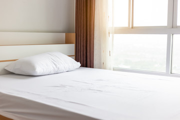 Cozy small bedroom in apartment or condominium. Little bed stay near window for seeing nice view. The room stay high floor of building. It is simply bedroom. It has pillow and white linen sheets