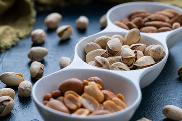 Roasted Nuts And Salted Pistachios In White Ceramic Bowl