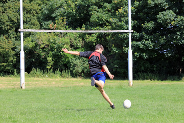 Teenage boy kicking a rugby ball to score a conversion. - Powered by Adobe