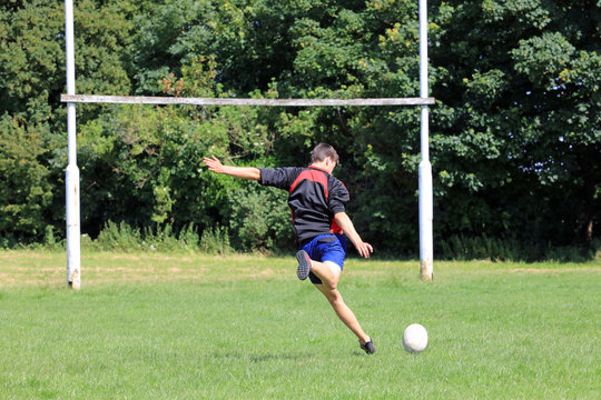 Teenage boy kicking a rugby ball to score a conversion.