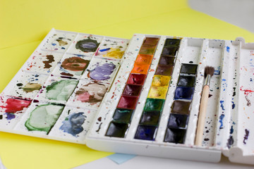 Set of professional watercolor paints and paintbrush for painting closeup. Selective focus. bright spring colors.